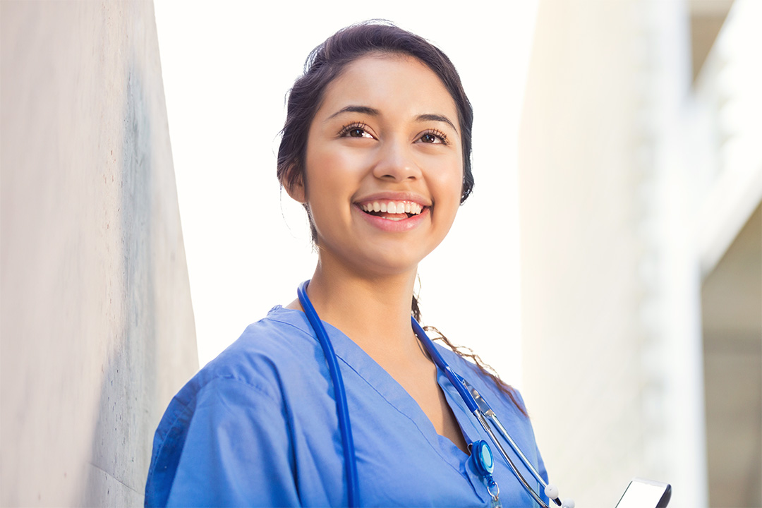 An applicant wearing scrubs and looking up towards the sky