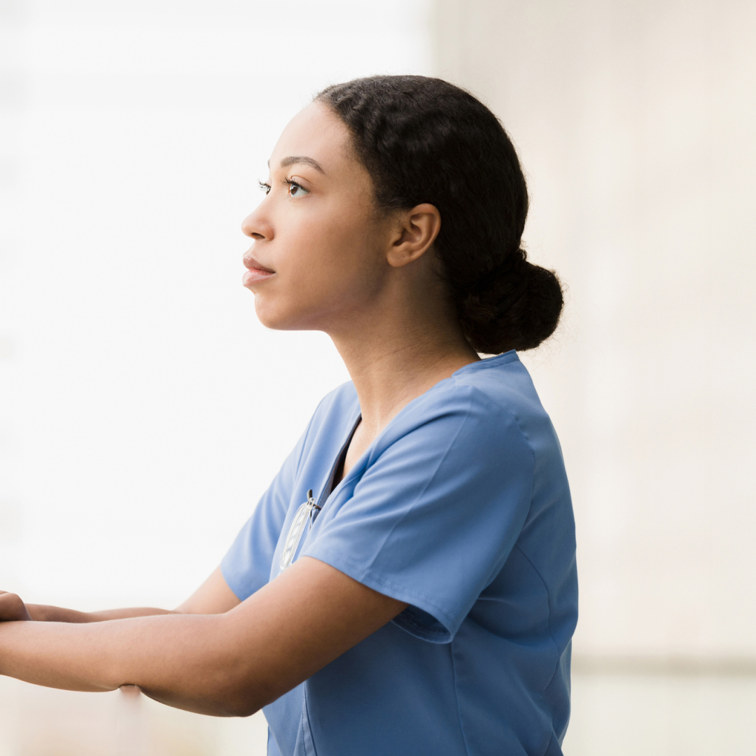 A nurse looking out into the distance, lost in thought.